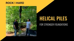 Worker installing helical pile at construction site